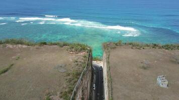 Road in the middle of limestone cliffs and turquoise sea in Bali, Indonesia video
