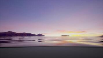 The sun is setting over the water with mountains in the background video