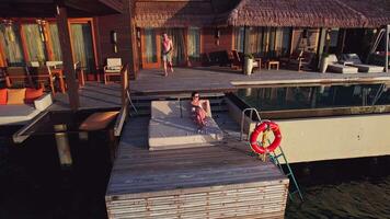 Couple relaxing in a bungalow on the water in the Maldives video