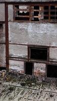 Damaged building with broken windows. Abandoned place after the war. Exterior of empty building during military actions. Vertical video