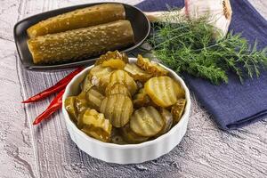 Sliced marinated cucumbers in the bowl photo