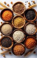A variety of different colored rice and beans are displayed in wooden bowls. The bowls are arranged in a row, with some bowls containing more beans than rice photo