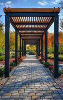 A long walkway with a wooden roof and a brick path. The walkway is lined with trees and bushes, and there are several potted plants along the way photo