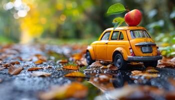 A toy car with an apple on top of it. The scene is set in autumn, with leaves on the ground photo