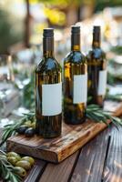 White wine bottles with blank labels on a wooden outdoor table photo