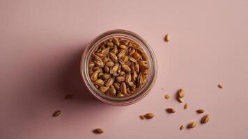 Top down view of a jar filled with seeds and honey on a pink background suitable for web banners with ample copy space image. photo