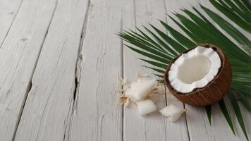 Coconut and palm leaves on white wooden surface Exotic vacation and nature background. photo