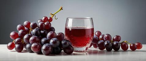 a glas jar filled with grape juice surrounded by red grapes on a white studio background. photo