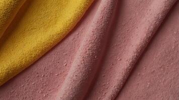 Top view of a yellow beach towel folded on a pink background with copy space image. photo