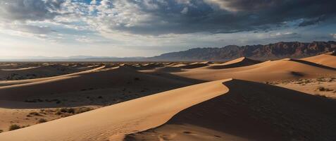 A beautiful landscape of a desert with large sand dunes and a cloudy sky. photo