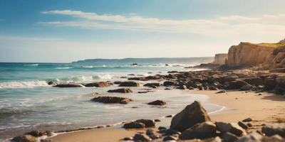 A beach scene with approaching waves reaching the shore, and a rocky outcropping in the distance. photo