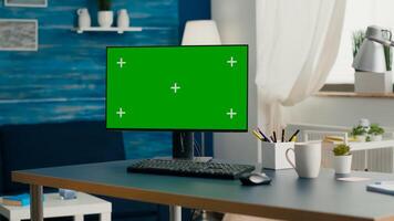 Desktop computer with mock-up green screen chroma key placed on desk in empty living room. Pc with isolated display in home office with nobody in ready for online business meeting photo