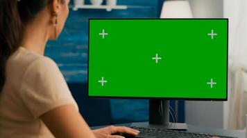 Close up of business woman use personal computer with mock up green screen chroma key. Freelancer sitting on chair at office desk working at financial graphs using isolated pc photo