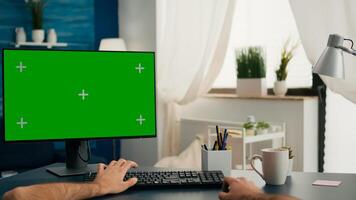 Pov of man hands sitting on office desk using computer with mock up green screen chroma key working photo