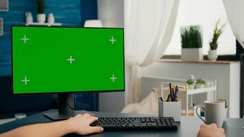 POV of caucasian man working on business conference using isolated pc. Male looking at computer with mock up green screen chroma key sitting on desk in living room photo