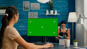 Freelancer searching the internet on green screen chroma key display using web advertisiment in chromakey PC. Home office computer with mockup photo