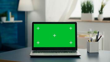 Laptop computer with mock up green screen chroma key standing on home office desk with nobody in it. Professional set up is ready for e commmerce courses using isolated pc photo