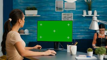 Caucasian woman working on mock up computer green screen chroma key for business communication project. Freelancer sitting at desk in office home using isolated pc photo
