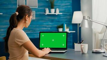 Freelancer woman searching business advertising using isolated pc standing in home office studio. Caucasian woman working with laptop computer with mock up green screen chroma key photo