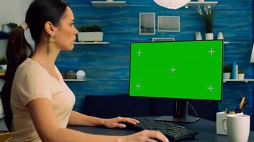 Caucasian female searching information about social media technology on computer with mock up green screen chroma key display. Woman browsing on network with isolated pc photo