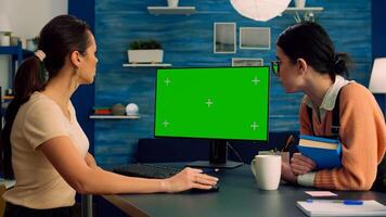 Teammates browsing on internet for commerce advertising using powerful computer with mock up green screen chroma key display. Collegues working on isolated pc sittings at desk table in office studio photo