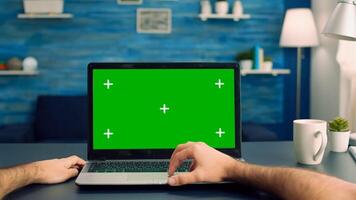 Point of view of man hands typing on laptop computer with mock up green screen chroma key display for e commerce courses. Freelancer using isolated device standing on desk table in home office studio photo
