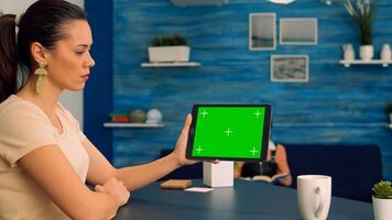 Caucasian female looking at tablet computer with mock up green screen for online .advertising. Woman looking at template chroma key isolated tablet computer display using technology internet photo