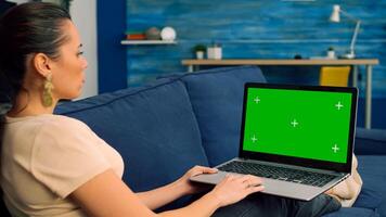 Business woman working on laptop computer with mock up green screen chroma key digital display. Caucasian female typing on keyboard writing ideas for marketing project using powerful isolated pc photo