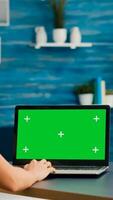 Freelancer woman searching business advertising using isolated pc standing in home office studio. Caucasian woman working with laptop computer with mock up green screen chroma key photo