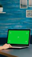 Woman working at businees project for company using laptop computer with mock up green screen chroma key. Caucasian freelencer using isolated pc while standing in home office studio photo