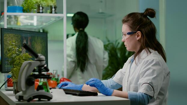 Chemist researcher analyzing test sample putting under microscope for pharmaceutical experiment. Scientist engineering researching for organic gmo plants while working in microbiology food laboratory photo