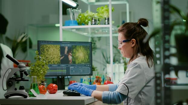 Scientist woman researcher typing biochemistry expertise on computer for microbiology experiment. Medical team working in pharmaceutical laboratory analyzing genetic mutation photo