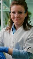 Portrait of smiling biologist woman analyzing genetically modified organism for microbiology experiment. Chemist scientific analyzing organic plants working in microbiology agriculture laboratory photo