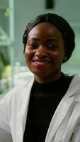 Portrait of biologist researcher woman in white coat looking into camera while standing in microbiology laboratory. Specialists team researching genetic mutation developing medical scientific GMO dna test photo