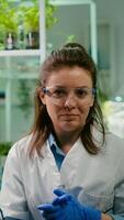Pov of chemist woman in white coat analyzing with biologists team during online videocall meeting while sitting in microbiology lab. Specialist researching genetic mutation developing dna test photo