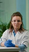 Pov of botanist woman in white coat listening chemists team during online videocall meeting while sitting in pharmaceutical lab. Specialists team researching genetic mutation developing dna GMO biology test photo