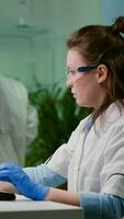 Chemist researcher analyzing test sample putting under microscope for pharmaceutical experiment. Scientist engineering researching for organic gmo plants while working in microbiology food laboratory photo