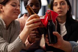 Business people clinking glasses and bottles of beer at office party celebration after work. Friends meeting to enjoy drinks after work, doing cheers gesture for celebration. Close up. photo