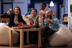 Business people celebrating games play win in office, doing drinks party after work hours. Happy colleagues enjoying celebration with beer and pizza, doing leisure activity. photo