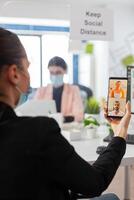 Business woman with face mask during conference on smartphone, keeping social distancing as prevention against coronavirus flu during global pandemic. Using internet web call chat message photo