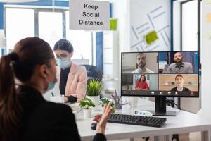 Businesswoman discussing with remote management team during online videocall meeting conference on computer working at marketing presentation in startup company office. Teleconference call on screen photo