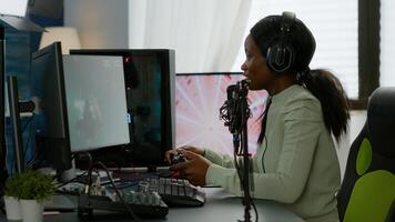 Afro american space shooter player happy after winning virtual competiton using RGB powerful computer. Online streaming cyber performing during games tournament in home with neon lights. photo