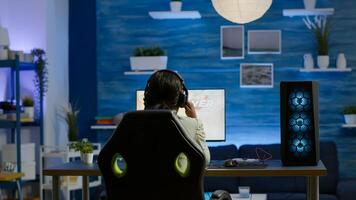 Angry african pro woman gamer losing space shooter videogame during online championship. Cyber player testing virtual games using powerful personal computer in gaming room during esports tournament photo