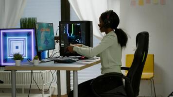 Winner black gamer sitting on gaming chair playing space shooter games with wireless controller. Pro cyber man streaming online videogames for esport tournament on RGB powerful personal computer photo