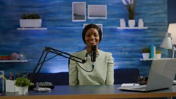 Portrait of african vlogger working in cozy studio, smiling at camera ready to start new podcast show. On-air online production internet broadcast show host streaming web content record digital blog photo