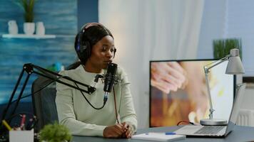 Creative influencer with headphones ready to speak during live on social media recording vlog. On-air online production internet broadcast show host streaming podcast content from studio photo