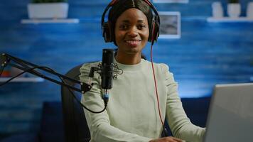 Portrait of african smiling blogger looking at camera before starting live from home studio podcast. Content creator vlogger woman recording brodcast streaming online content for social media photo