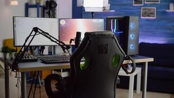 Streaming professsional microphone in empty gaming home studio with neon lights. Game is over on display of RGB professional powerful computer and stream chat is prepared for virtual tournament photo
