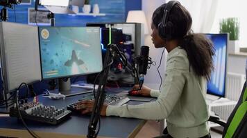 Competitive black gamer with headphones using stream chat on powerful computer winning online shooter game late at night. Virtual online streaming cyber checking sound performing in gaming tournament photo