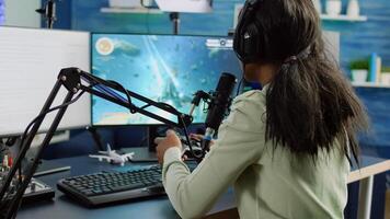 African streamer woman talking with team into headphones and winning games competition. Professional gamer streaming online videogames with new graphics on powerful computer from gaming room photo
